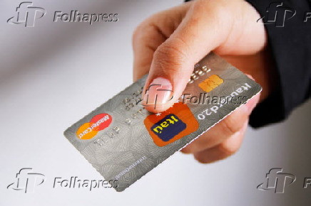 Mão segura um cartão de crétido do banco Itaú da bandeira MasterCard
