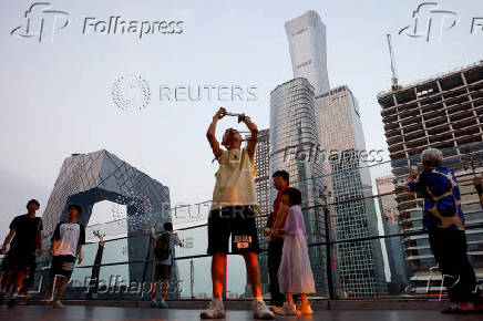 People visit a terrace of a shopping mall overlooking the central business district (CBD), in Beijing