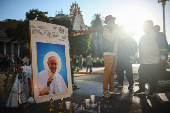 People stand next to a picture of the late Pope Francis, in Buenos Aires