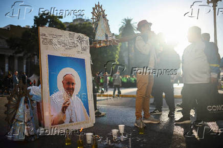 People stand next to a picture of the late Pope Francis, in Buenos Aires
