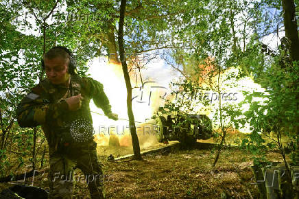 A Ukrainian serviceman fires a howitzer towards Russian troops at a front line in Zaporizhzhia region