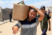 Palestinians carry aid supplies they received from the U.S.-backed Gaza Humanitarian Foundation, in Khan Younis
