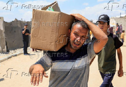 Palestinians carry aid supplies they received from the U.S.-backed Gaza Humanitarian Foundation, in Khan Younis