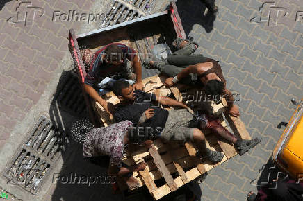 Palestinians transport a man injured by Israeli fire while seeking aid, in Khan Younis