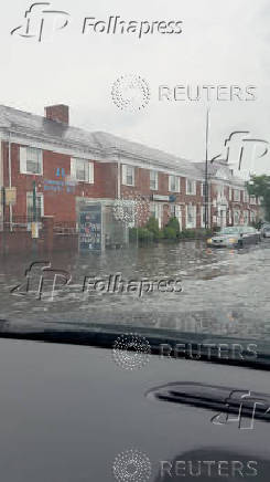 Vehicles navigate flooded New York street after heavy downpours