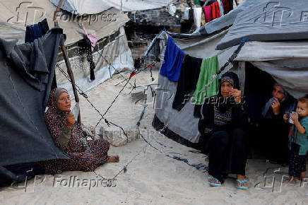 Palestinians, displaced by the Israeli offensive, shelter at a tent camp on a beach amid summer heat, in Gaza City