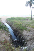 Água de chuva desce na praia com esgoto