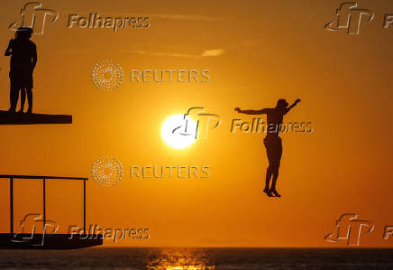 A man jumps into the Adriatic sea during warm weather in Zadar