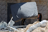 Palestinians carry their belongings after Israel's decision to demolish their homes in Nur Shams camp