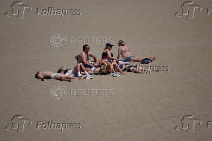 People enjoy the sun on the beach in Santa Monica