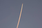 A military aircraft flies in the sky following a barrage of missiles launched from Iran, as seen over Tubas