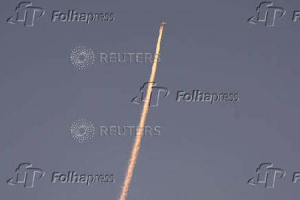 A military aircraft flies in the sky following a barrage of missiles launched from Iran, as seen over Tubas