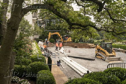 Workers reconstruct the Rose Garden to pavement at the White House