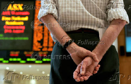 FILE PHOTO: A visitor the Australian Securities Exchange in Sydney waits for trading to begin