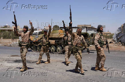 FILE PHOTO: Syrian security forces walk together along a street in Sweida