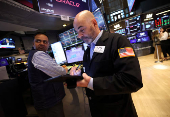 Traders work on the floor at the New York Stock Exchange, in New York City