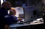 Traders work on the floor at the New York Stock Exchange, in New York City