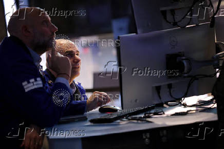 Traders work on the floor at the New York Stock Exchange, in New York City