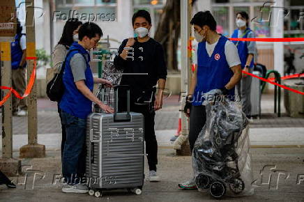 Hong Kong residents affected by the fire gather their belongings from their apartments