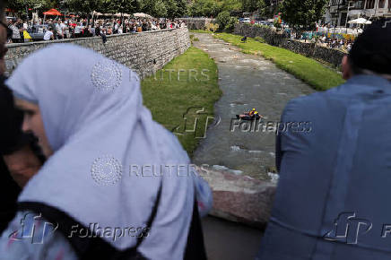 Sports enthusiasts compete while floating on inner tyre tubes during the tyre festival 'Bunar Fest' in Prizren