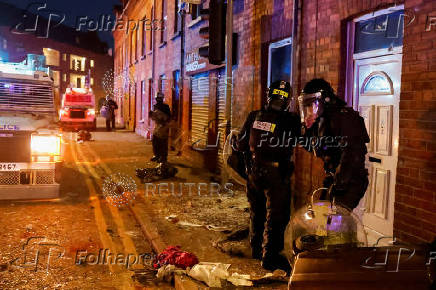 Armed police in riot gear stand guard during a second night of riots, in Ballymena