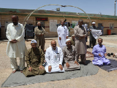 Iranian pilgrims who were rerouted through Iraq pray near the Arar border crossing