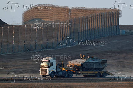 A truck carrying a tank drives on the Israeli side of the Israel-Gaza border