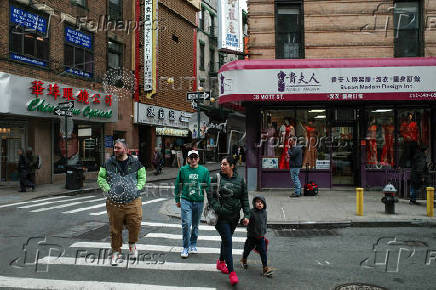 Tourists cross Mott Street in the Chinatown neighborhood of Manhattan in New York City
