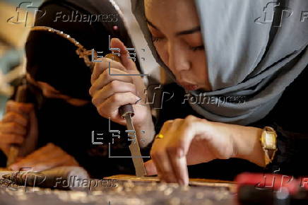 Afghan girl teach Nuristani wood carving skills at a workshop in Kabul