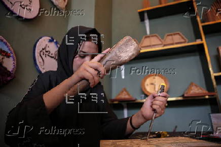 Afghan girl teach Nuristani wood carving skills at a workshop in Kabul