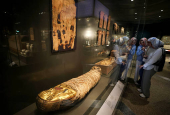 Tourists look at museum exhibits displayed at the Grand Egyptian Museum