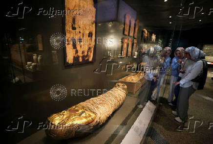 Tourists look at museum exhibits displayed at the Grand Egyptian Museum