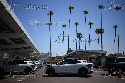 A Waymo driverless vehicle enters a Waymo charging station in Santa Monica