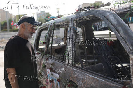 A man looks at an ambulance burned by Israeli attacks on a street in Tehran