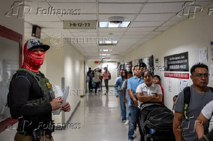 A migrant is detained by federal immigration officers at U.S. immigration court