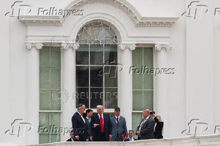 U.S. President Trump talks with architect McCrery as they walk on the roof of the White House in Washington