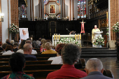A priest celebrates a Mass next to a picture of late Pope Francis, after the death of the pontiff was announced by the Vatican, in St. John's Cathedral in Warsaw