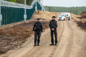 Finnish Border Guard at the barrier fence between Finland and Russia