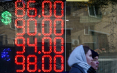 FILE PHOTO: A board shows currency exchange rates in Moscow