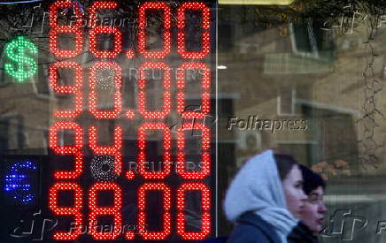 FILE PHOTO: A board shows currency exchange rates in Moscow