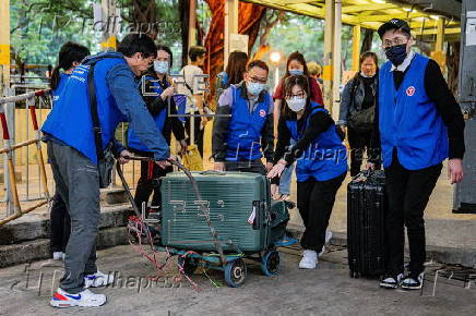 Hong Kong residents affected by the fire gather their belongings from their apartments