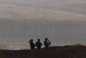 Soldiers stand on the Israeli side of the Israel-Gaza border