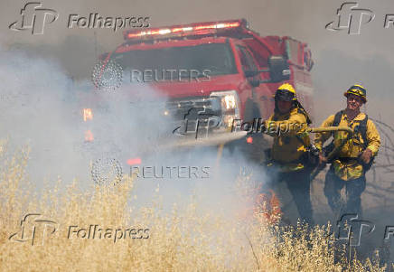 Firefighters battle flames at brushfire in Woodland California