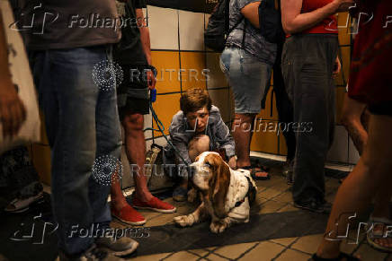 People take cover inside a cable car tunnel following a missile attack from Iran on Israel, at Haifa