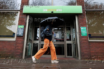 FILE PHOTO: A passer-by walks past a job centre in Borough, in London