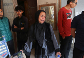 Palestinians inspect the site of an Israeli strike on a house, in Gaza City