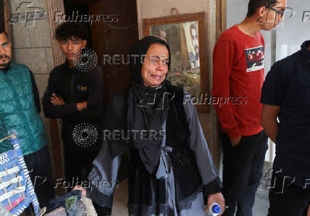 Palestinians inspect the site of an Israeli strike on a house, in Gaza City