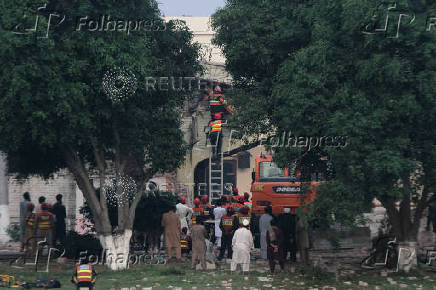 Rescuers search for survivors in a damaged building after it was hit by an Indian strike in Muridke