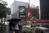 Pedestres enfrentam chuva e queda de temperatura em SP