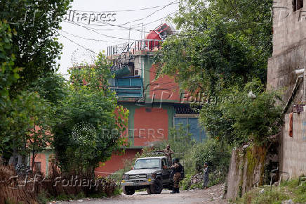 Security force personnel stand guard in front of Bilal Mosque after it was hit by an Indian strike in Muzaffarabad